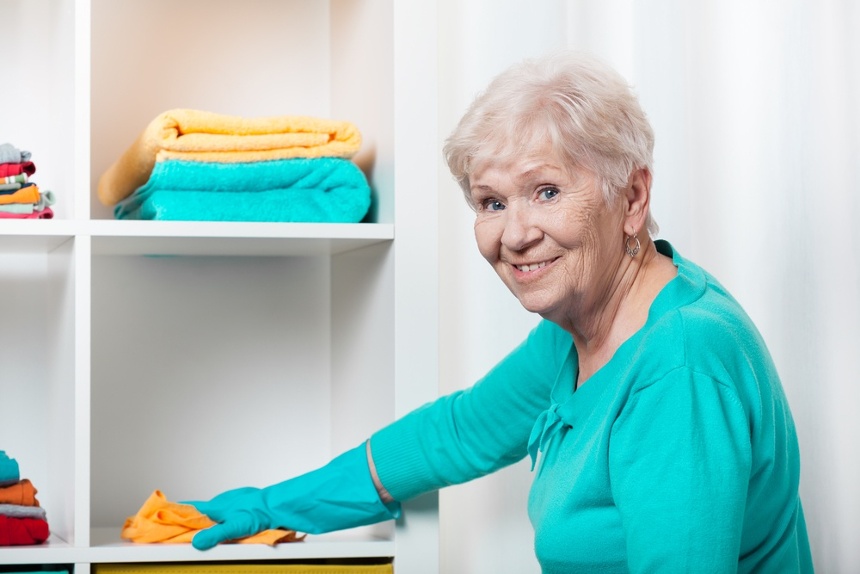 Smiling senior woman cleaning house before Christmas